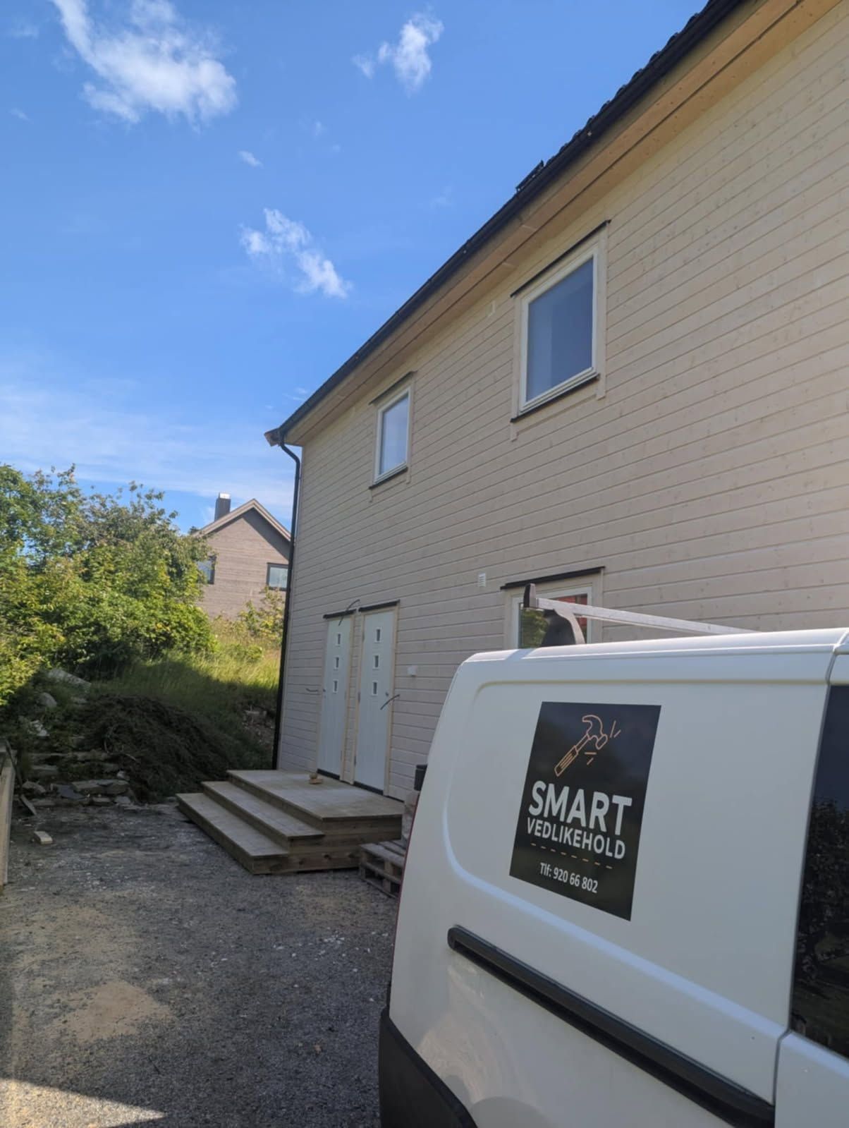 Firmabil med Smart Vedlikehold-logo utenfor bolig med ny kledning